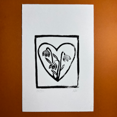 Black Hand carved lino print featuring three snowdrops framed by a heart.